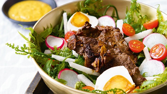 leafy green salad with beef tapa, salted egg, and pako fern greens 