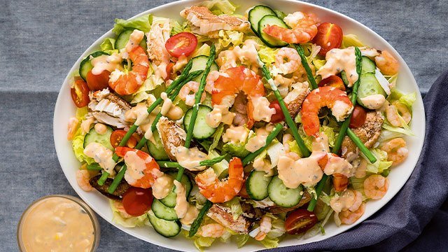 cold seafood salad with shrimp, cucumbers, and asparagus on a plate