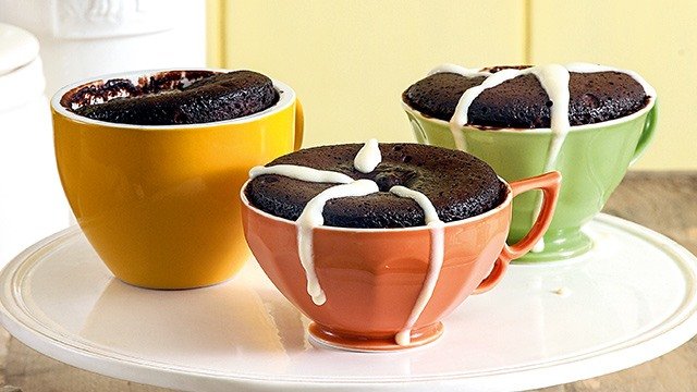 yellow, orange, and green mugs filled with molten lava chocolate cakes