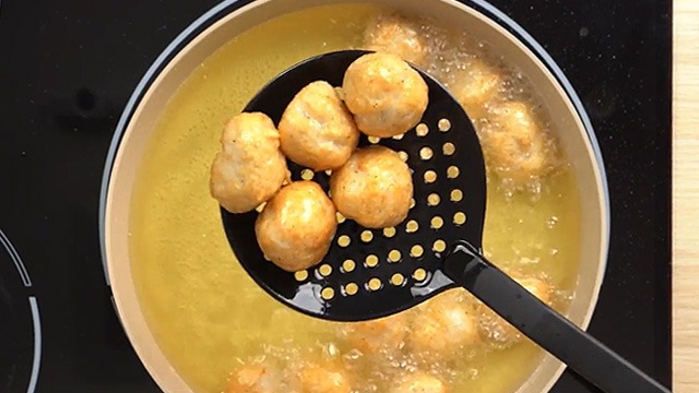 chicken balls frying in oil and turned golden brown