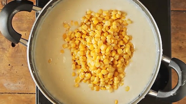 corn added to maja blanca mixture in the pot