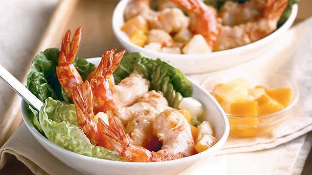 hot prawn salad with mangoes in a white oval bowl