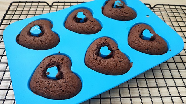 silicone mold with chocolate cupcake on cooling rack
