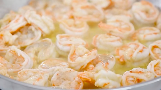 cooked peeled and deveined shrimp in a pan with garlic butter oil